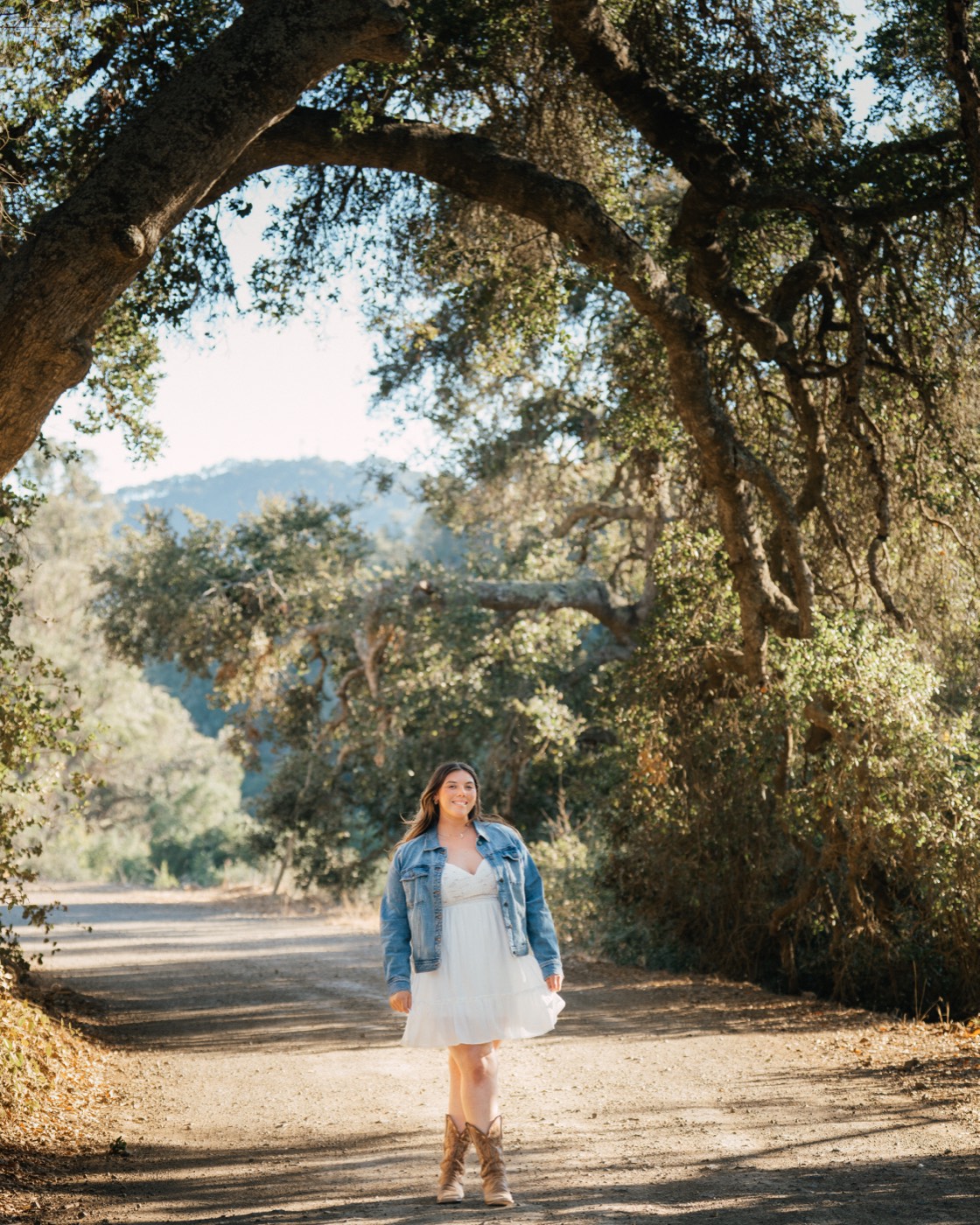 Senior portrait in a white dress beneath an arching oak tree canopy — Arroyo Grande senior photographer