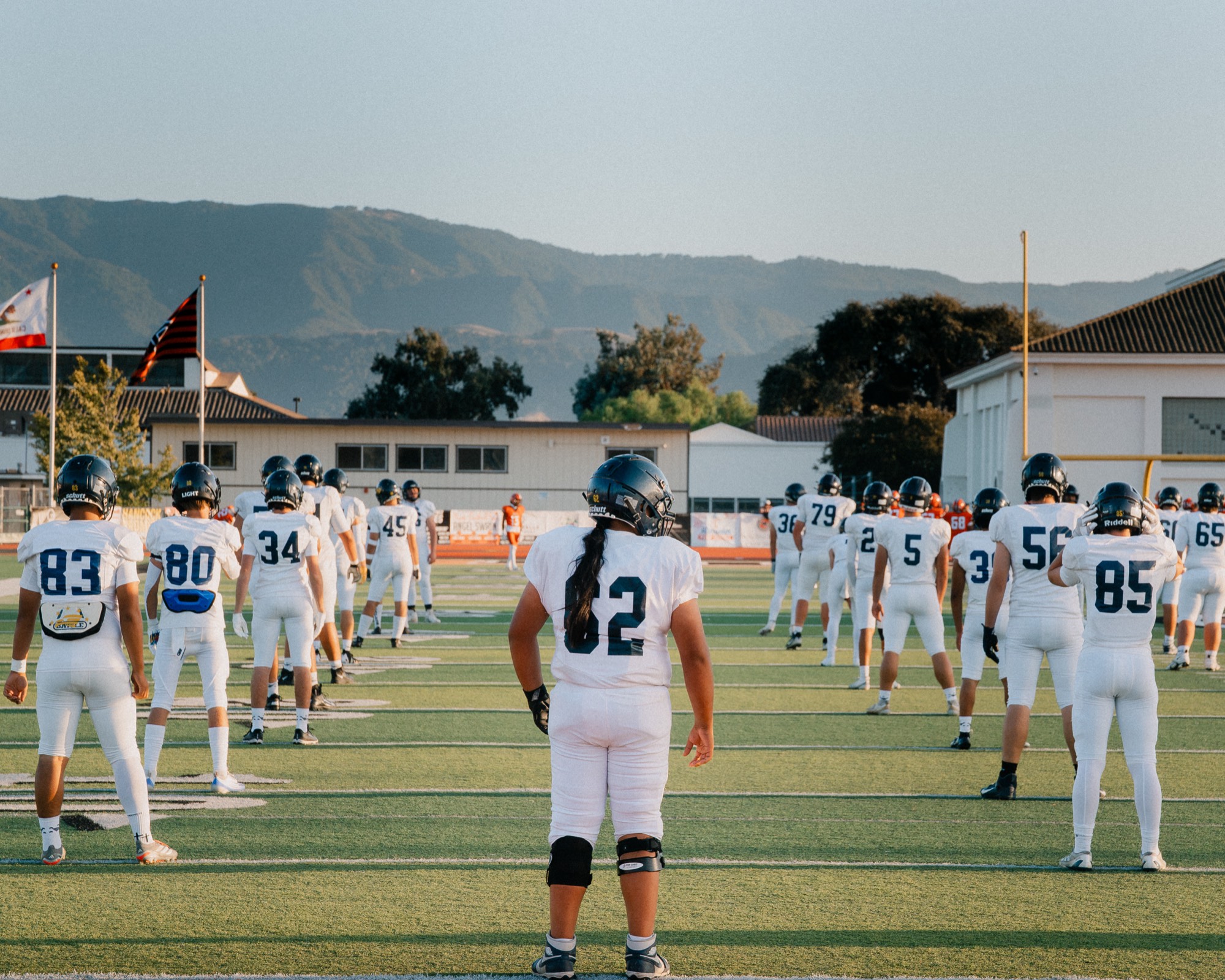 Arroyo Grande football players lined up before kickoff with mountains in the background